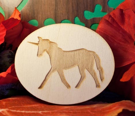 Unicorno al passo inciso su ovale in legno